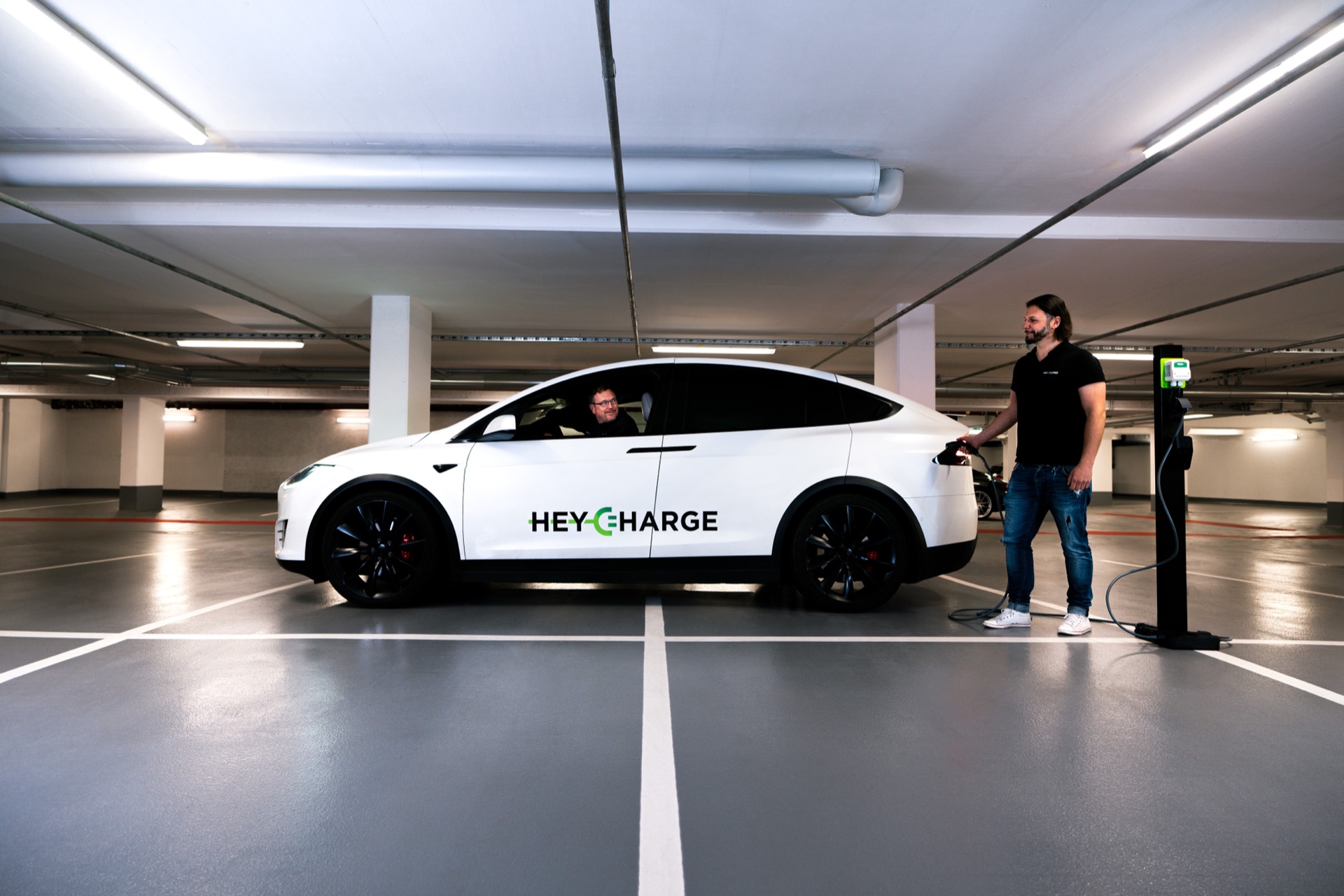 HeyCharge founders plugging in a Tesla at a HeyCharge-equipped garage